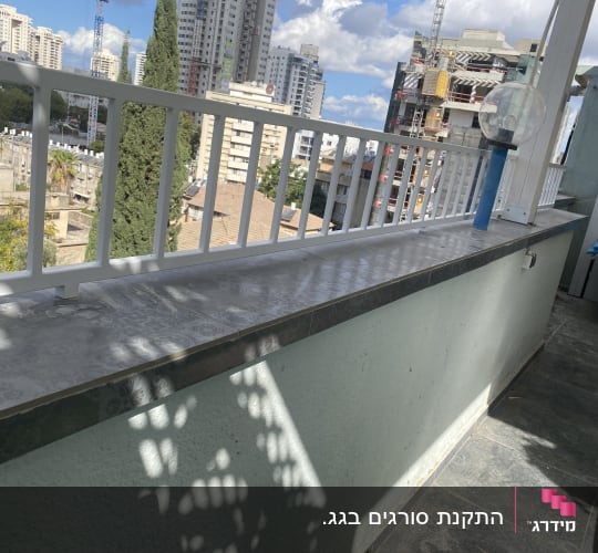 מעקה מרפסת עם נוף עירוני ברקע